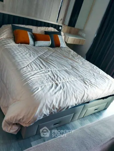 Cozy bedroom with stylish bedding and under-bed storage in modern apartment.