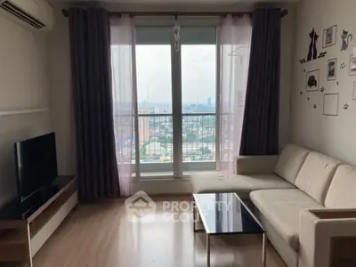 Modern living room with city view, featuring a cozy sofa and large windows.