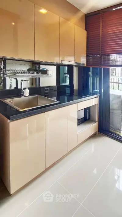 Modern kitchen with sleek cabinetry and large window for natural light