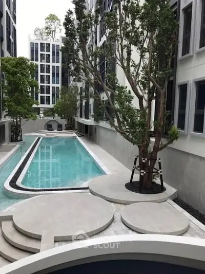 Modern apartment complex with sleek pool and lush greenery