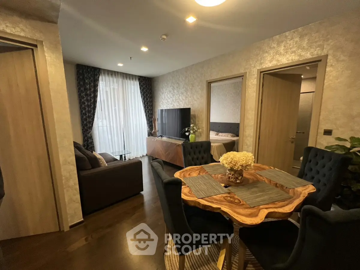 Elegant living room with dining area, featuring modern decor and natural light, perfect for cozy gatherings.