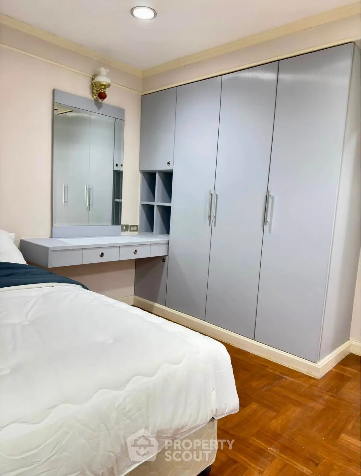 Spacious bedroom with modern wardrobe and vanity in elegant apartment.