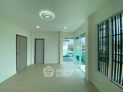 Spacious modern living room with large windows and balcony access