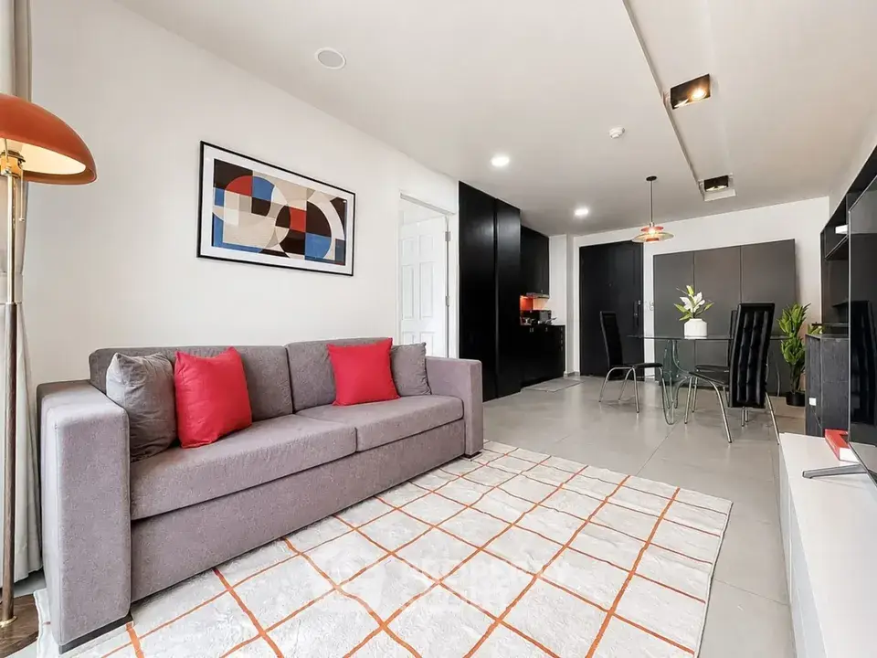 Modern living room with stylish decor and open layout, featuring a cozy sofa and dining area.