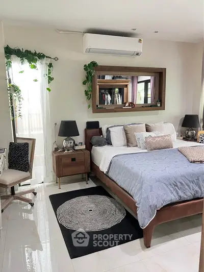 Luxurious bedroom with elegant decor, featuring a plush bed, stylish mirror, and modern air conditioning unit.
