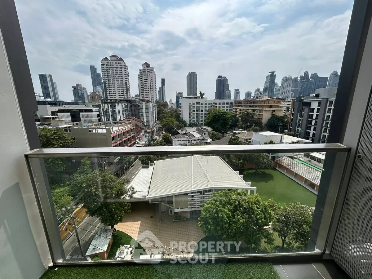 Stunning cityscape view from a modern balcony with lush greenery and skyline.