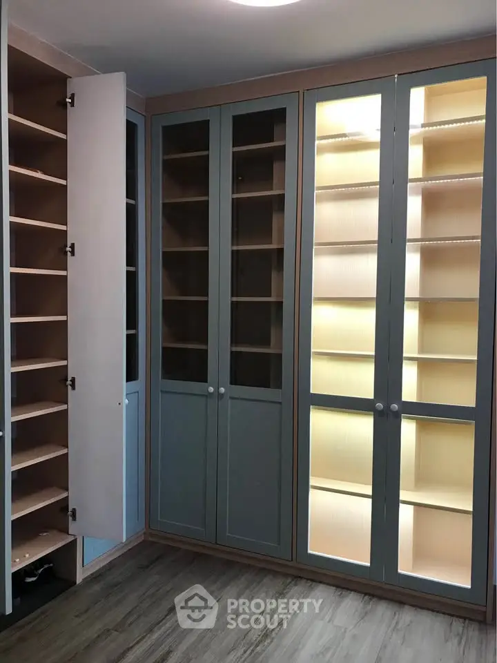 Spacious walk-in closet with ample shelving and elegant glass doors, perfect for organized storage.