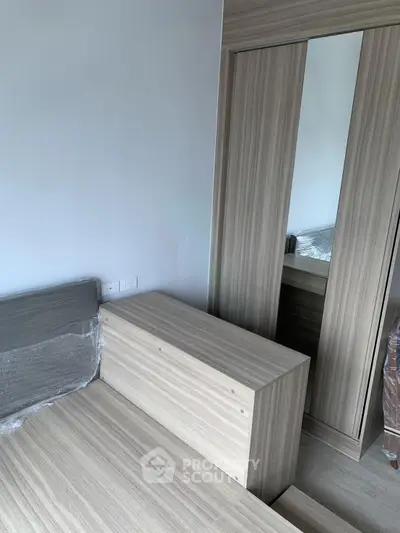 Modern bedroom with sleek wooden furniture and mirrored wardrobe