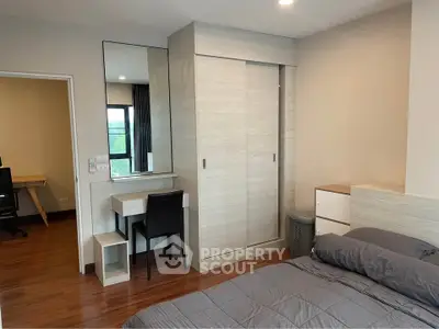 Modern bedroom with sleek wardrobe and cozy workspace, perfect for urban living.