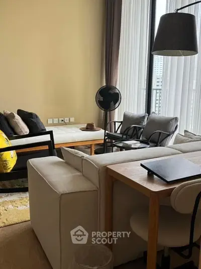 Modern living room with stylish furniture and large windows offering natural light.