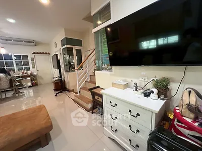 Spacious living room with modern decor and large TV, perfect for family gatherings.