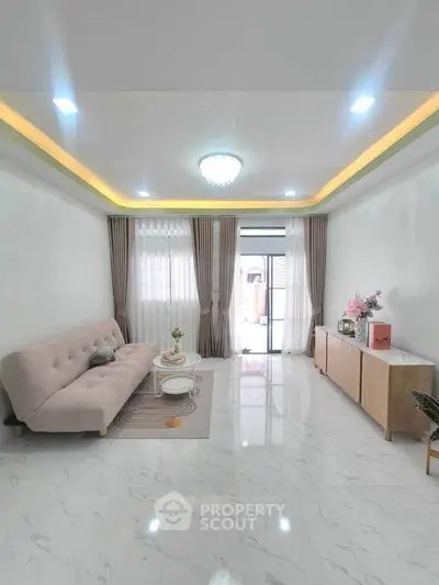 Elegant living room with modern decor, plush sofa, and natural light from large windows.