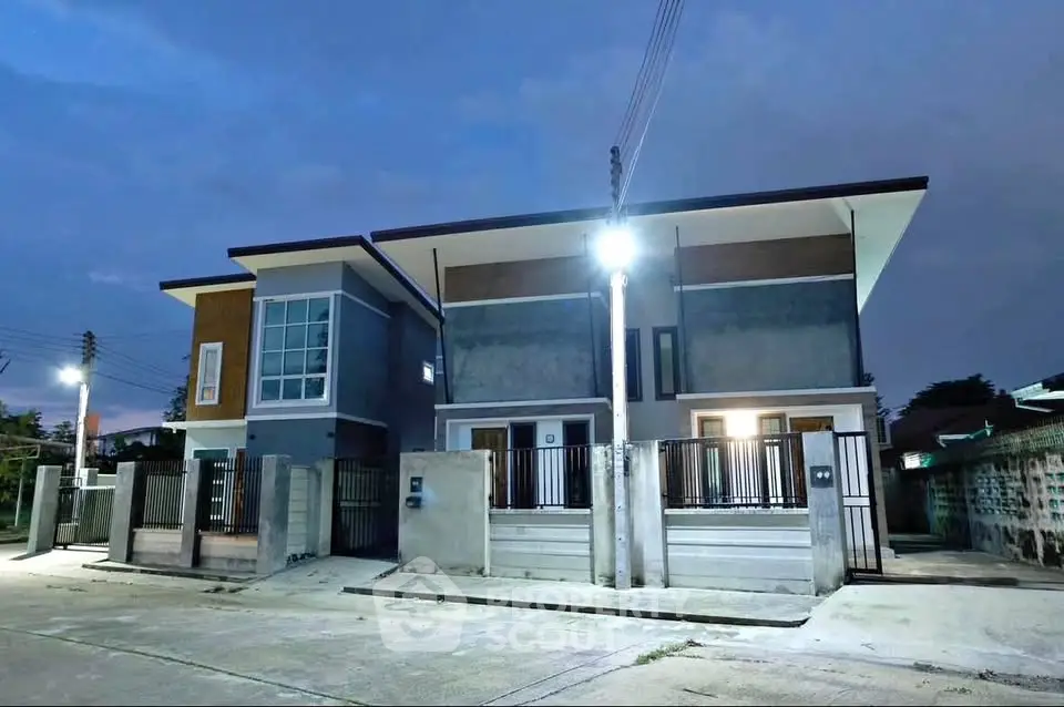 Modern duplex house exterior with sleek design and ample lighting at dusk.