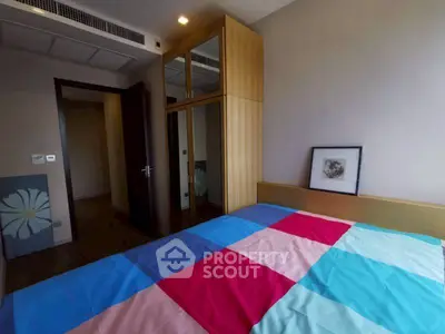 Cozy bedroom with colorful bedding and mirrored wardrobe