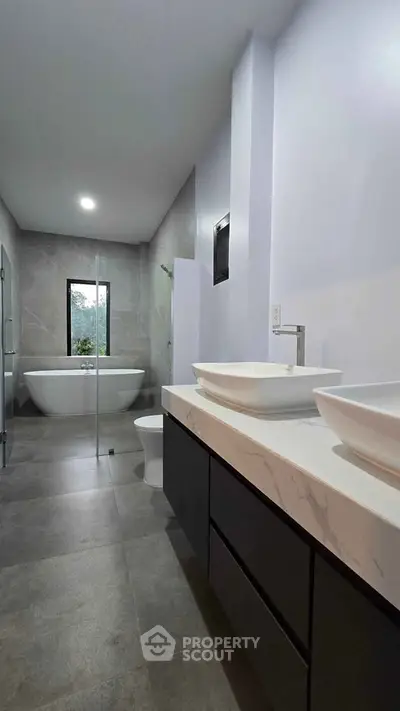 Luxurious modern bathroom with elegant fixtures and a spacious bathtub, perfect for relaxation.