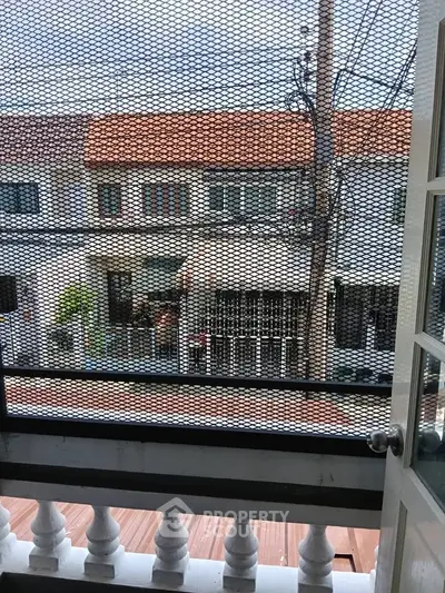Charming balcony view of residential neighborhood with classic architecture and open sky.