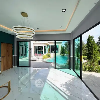 Luxurious living room with pool view and modern chandelier in elegant home