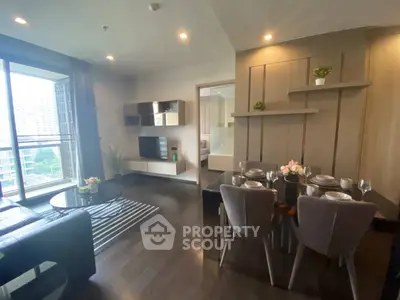 Modern living room with dining area and stylish decor in a high-rise apartment.
