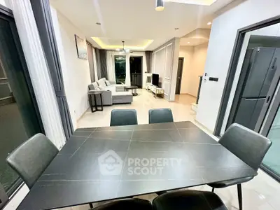 Modern open-plan living and dining area with sleek furniture and stylish decor.