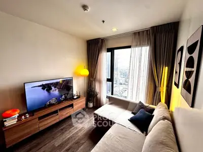 Modern living room with large window and stylish decor in a high-rise apartment.
