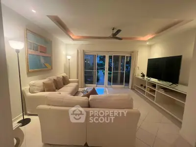 Elegant living room with modern decor, large TV, and cozy seating area, perfect for relaxation and entertainment.
