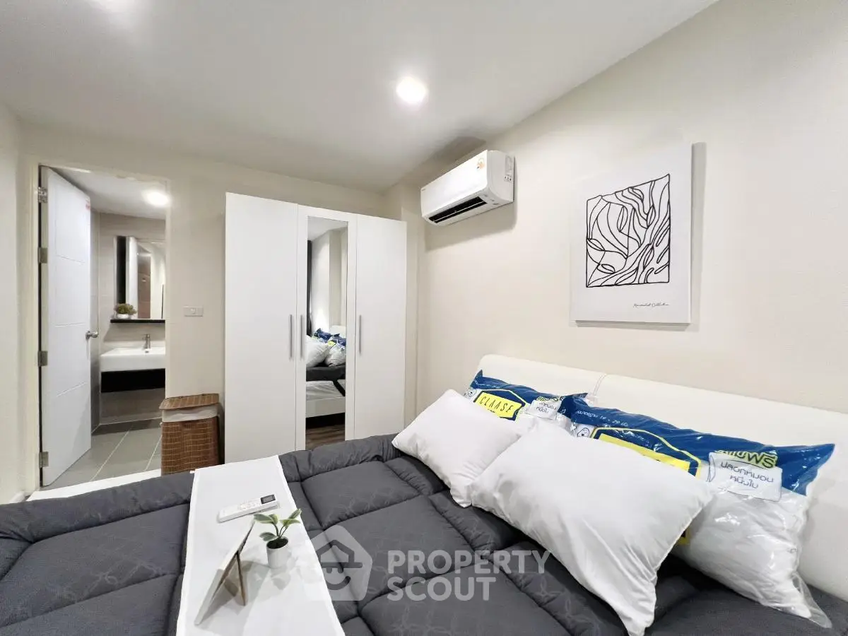 Modern bedroom with stylish decor and ensuite bathroom in a cozy apartment.