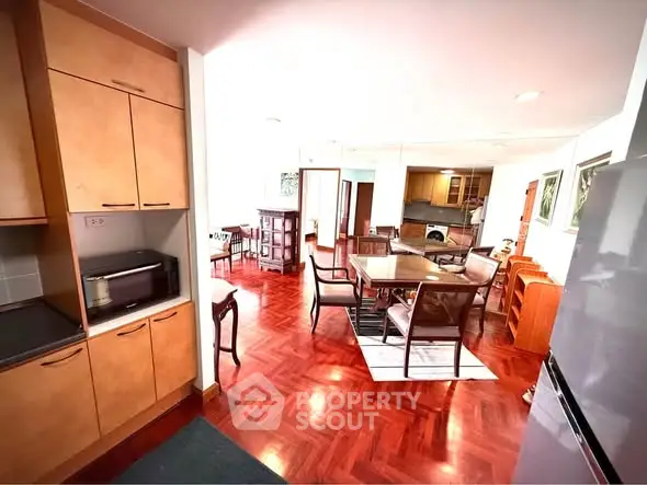 Spacious open-plan living and dining area with wooden flooring and modern furnishings.