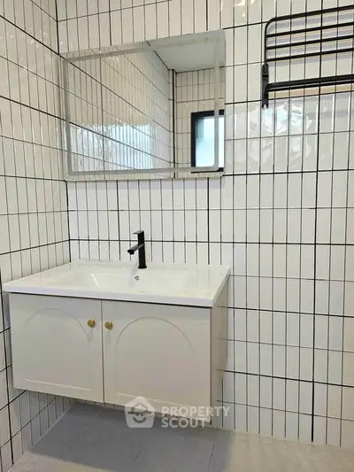 Modern bathroom with sleek white vanity and stylish black fixtures.