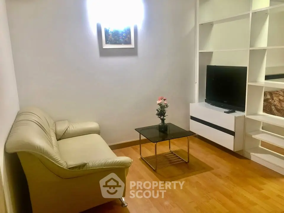 Cozy living room with modern decor, featuring a comfortable sofa, sleek TV unit, and elegant wooden flooring.