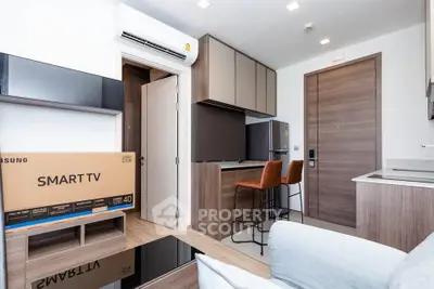 Modern living room with sleek design, featuring a Smart TV, stylish bar stools, and contemporary cabinetry.