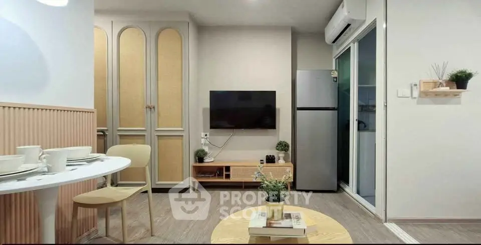 Modern living room with stylish decor and open layout, featuring a mounted TV and sleek furniture.