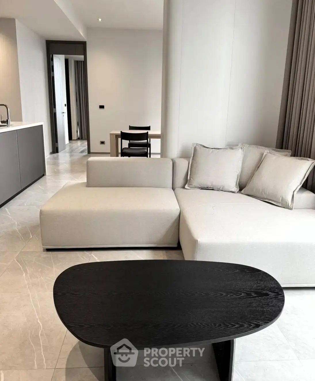 Modern living room with sleek furniture and open layout, featuring a stylish sofa and contemporary coffee table.