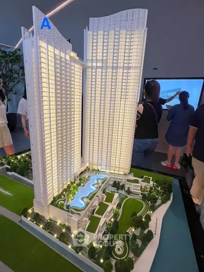 Stunning architectural model of modern high-rise residential complex with lush landscaping and pool.