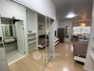 Modern studio apartment with open layout and sleek design, featuring a cozy living area and compact kitchen.
