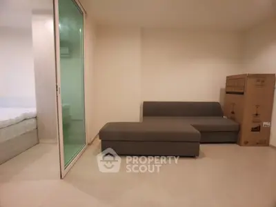 Modern living room with sofa and sliding glass door to bedroom