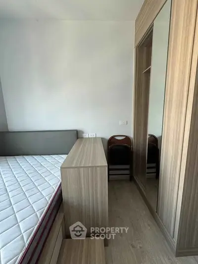 Modern bedroom with sleek wooden furniture and built-in wardrobe
