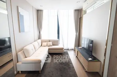 Modern living room with cozy sofa and large window, perfect for relaxation.