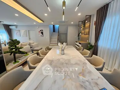 Luxurious open-plan living and dining area with elegant marble table and modern decor.
