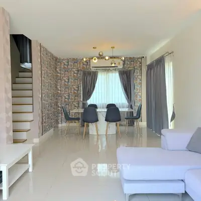 Modern living room with stylish decor, featuring a dining area and staircase, perfect for contemporary living.