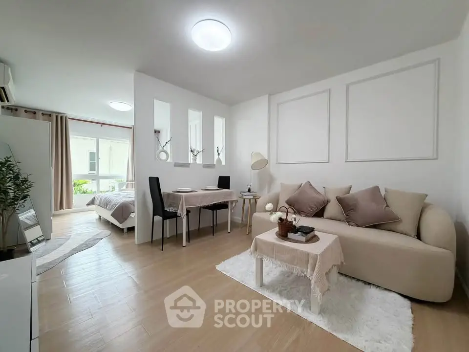 Modern open-plan living room with cozy sofa and dining area, featuring elegant decor and natural light.