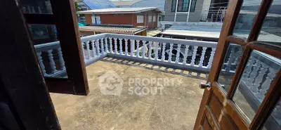 Spacious balcony with classic railing and urban view, perfect for relaxation and outdoor activities.
