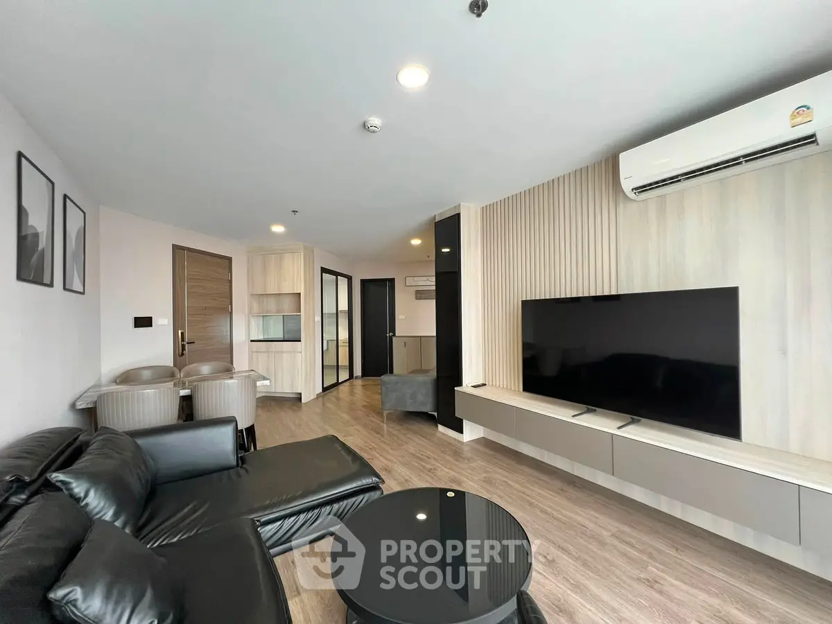 Modern living room with sleek furniture and large TV in stylish apartment