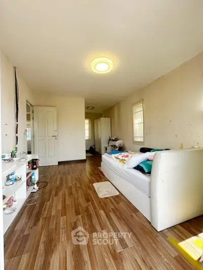 Spacious living room with wooden flooring and cozy sofa in bright apartment