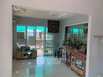 Spacious living area with balcony access and decorative elements