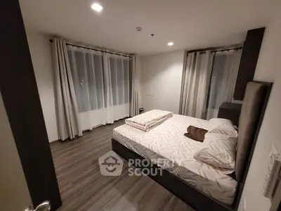 Cozy modern bedroom with stylish decor and large windows