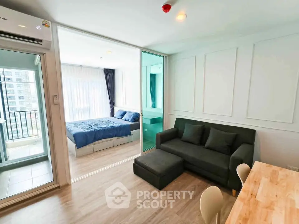 Modern condo interior with living room and bedroom, featuring a cozy sofa and natural light.