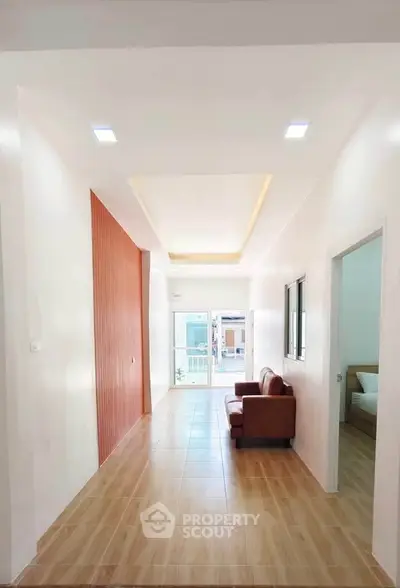 Spacious modern living room with elegant wooden flooring and stylish sofa, perfect for relaxation and entertaining.