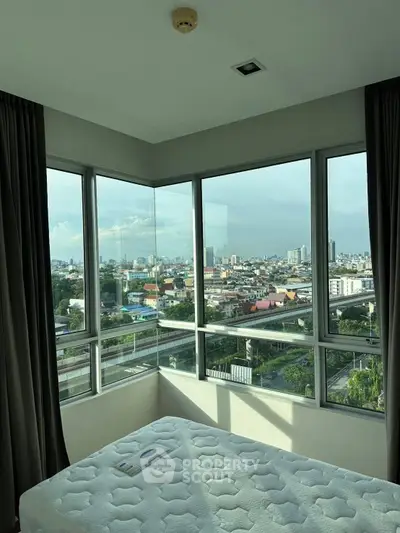 Corner bedroom with panoramic city view and large windows in modern apartment.