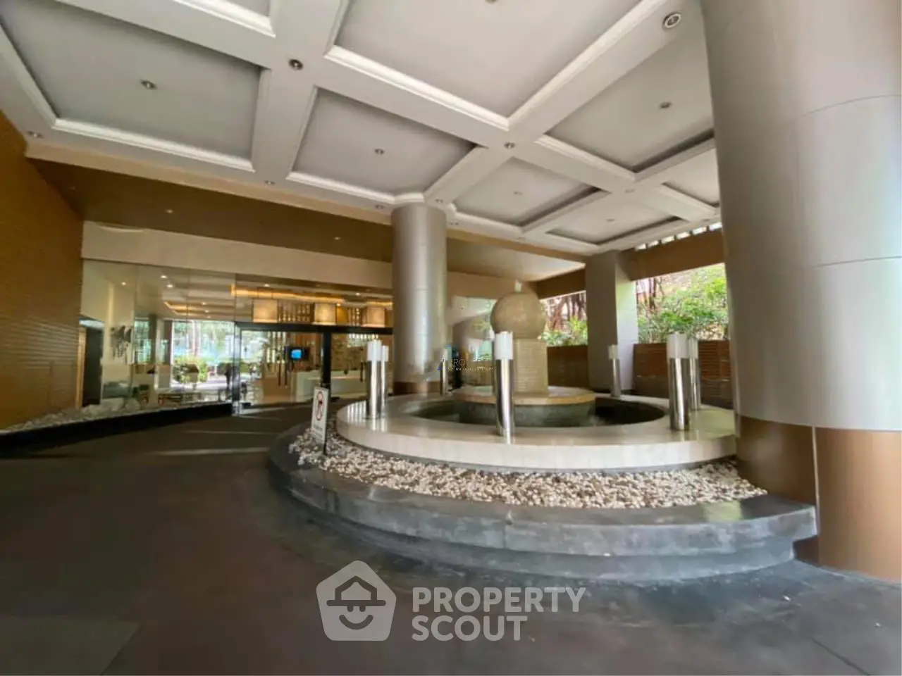 Luxurious building entrance with elegant water fountain and modern design.