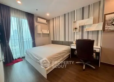 Modern bedroom with stylish decor and city view, featuring a cozy workspace and elegant furnishings.